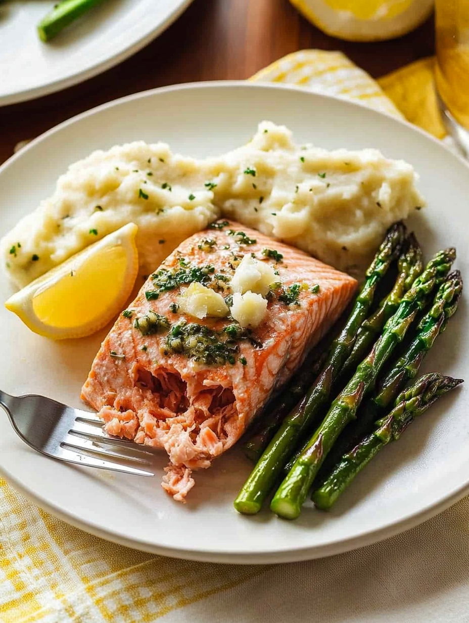 Une assiette avec du saumon, pommes de terre et asperges.