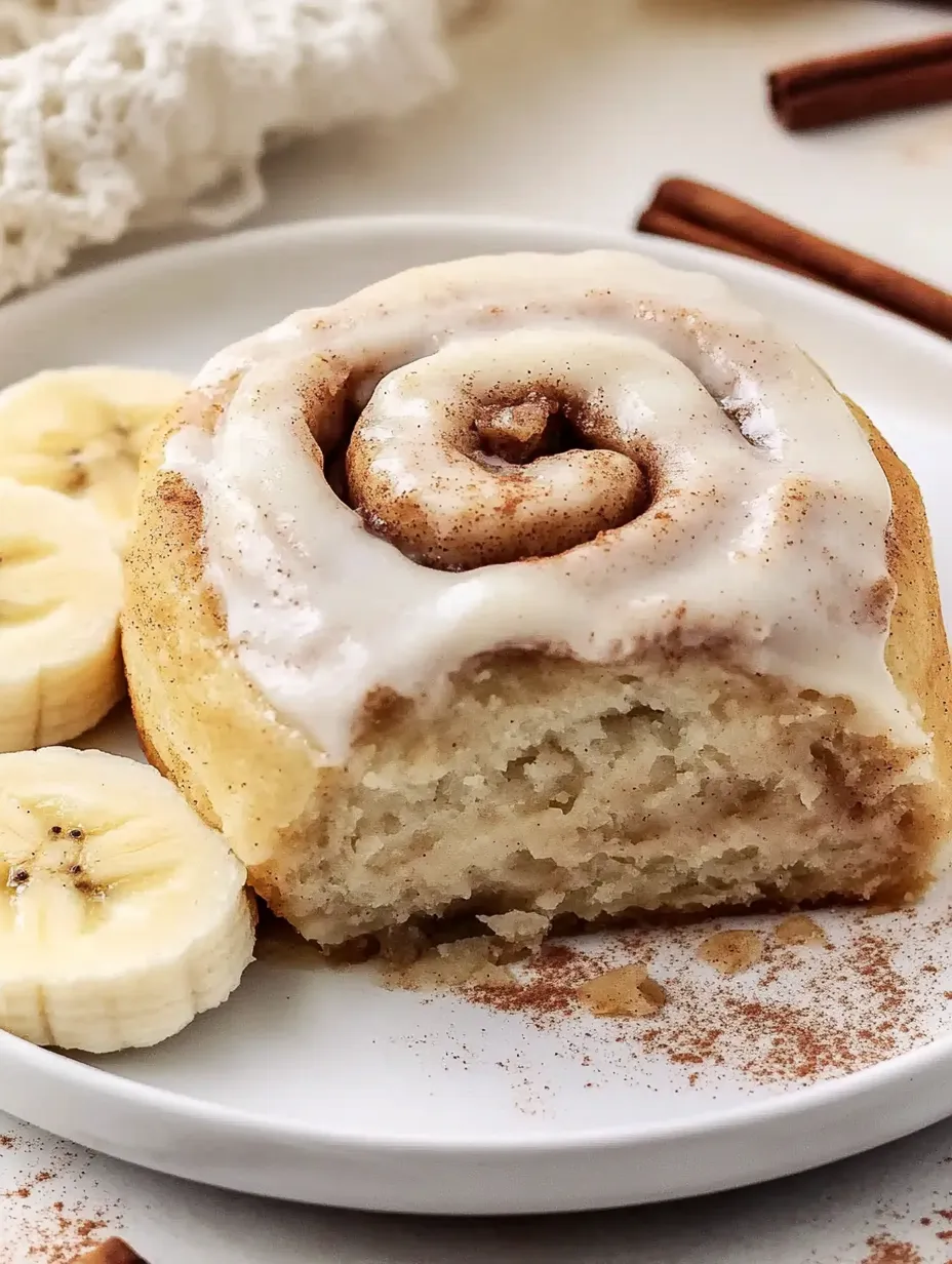 Une assiette avec une banane et un roulé moelleux.
